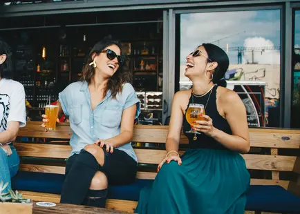 Two women smiling with beers